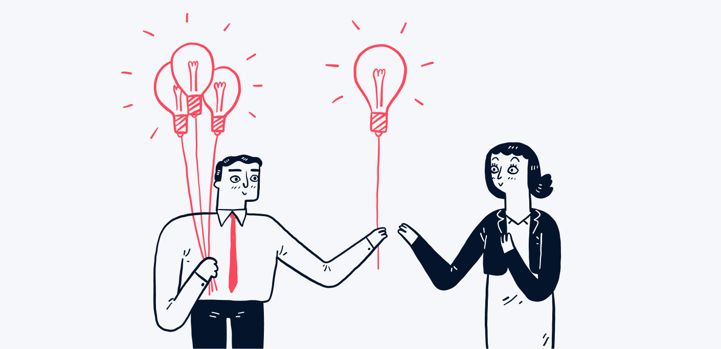 Man hands a light bulb balloon to a woman