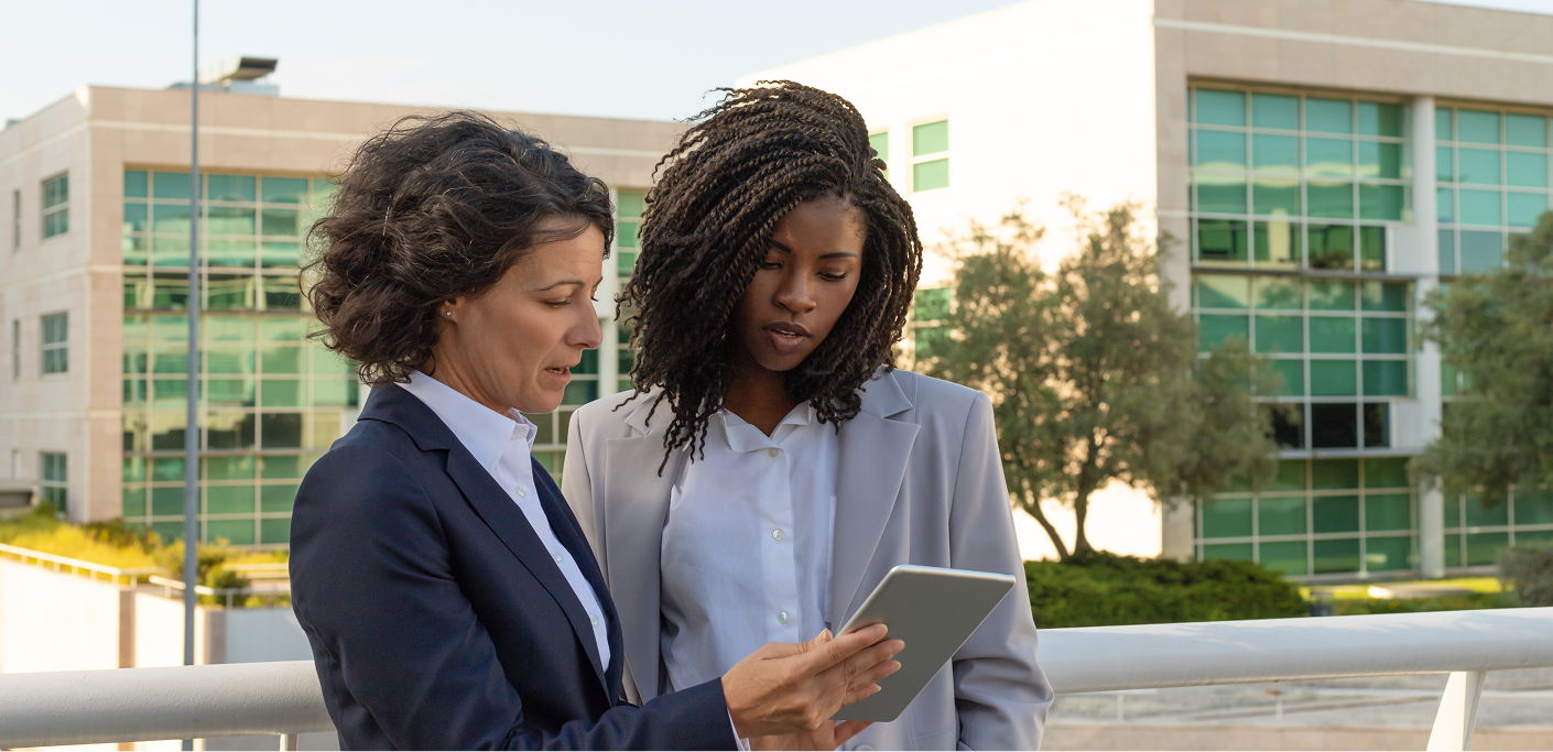 Property practitioner shows a young property practitioner a tablet screen