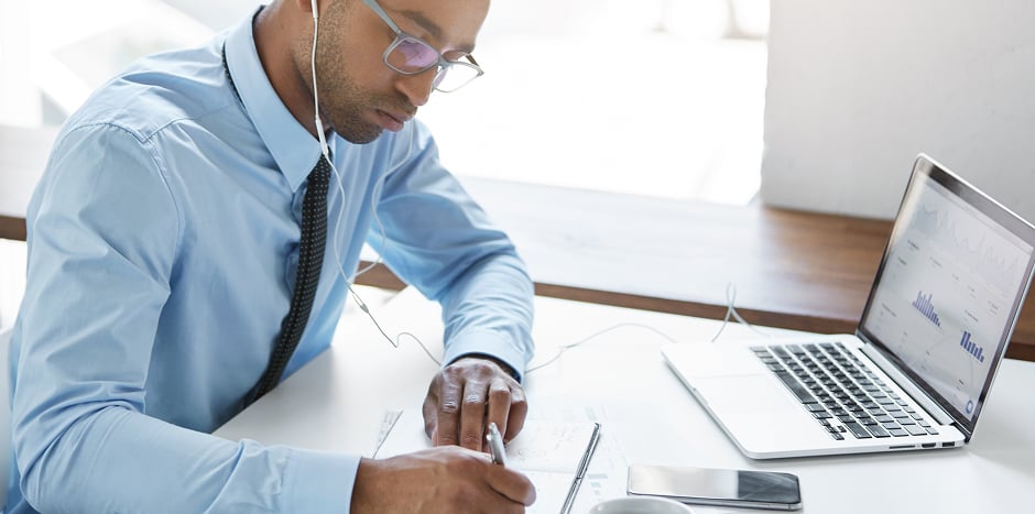 man with earphones working at his desk