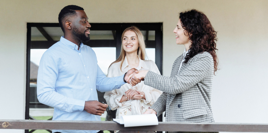 Real estate client shakes hands with a property practitioner during a negotiation