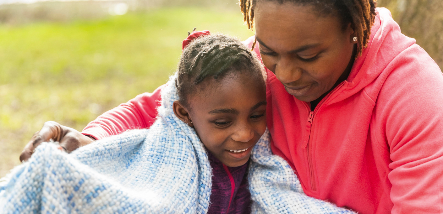 Mother wraps her daughter in a blanket