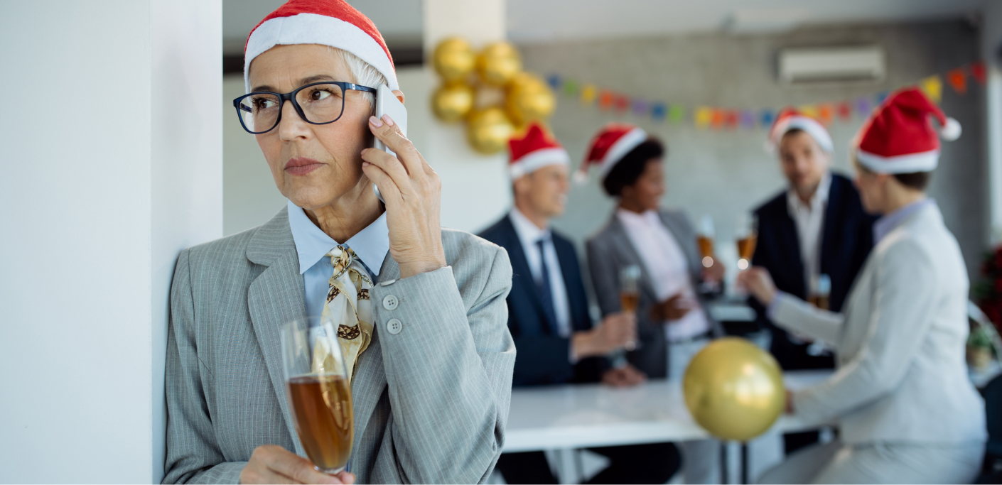 Women answers here phone during a holiday season office party