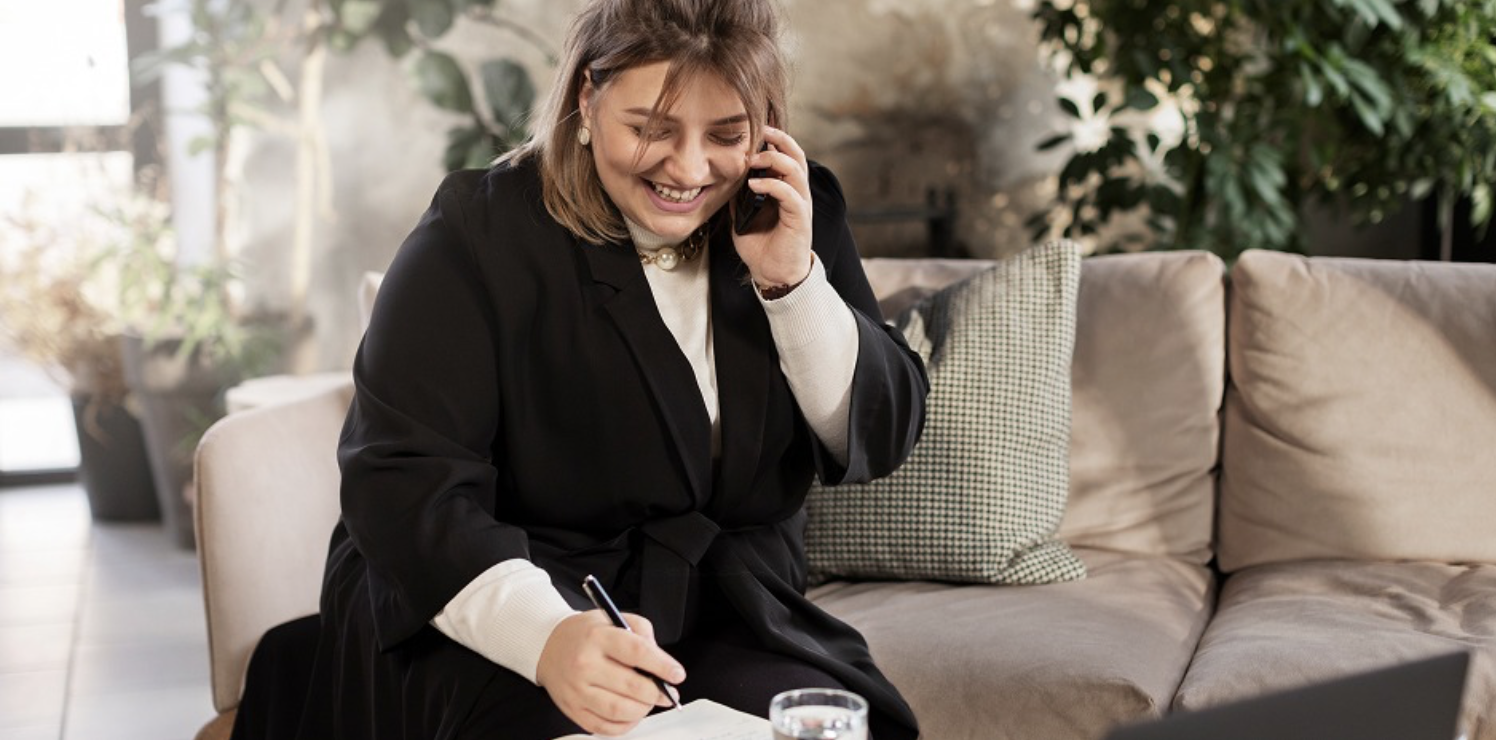 business woman taking notes while on the phone